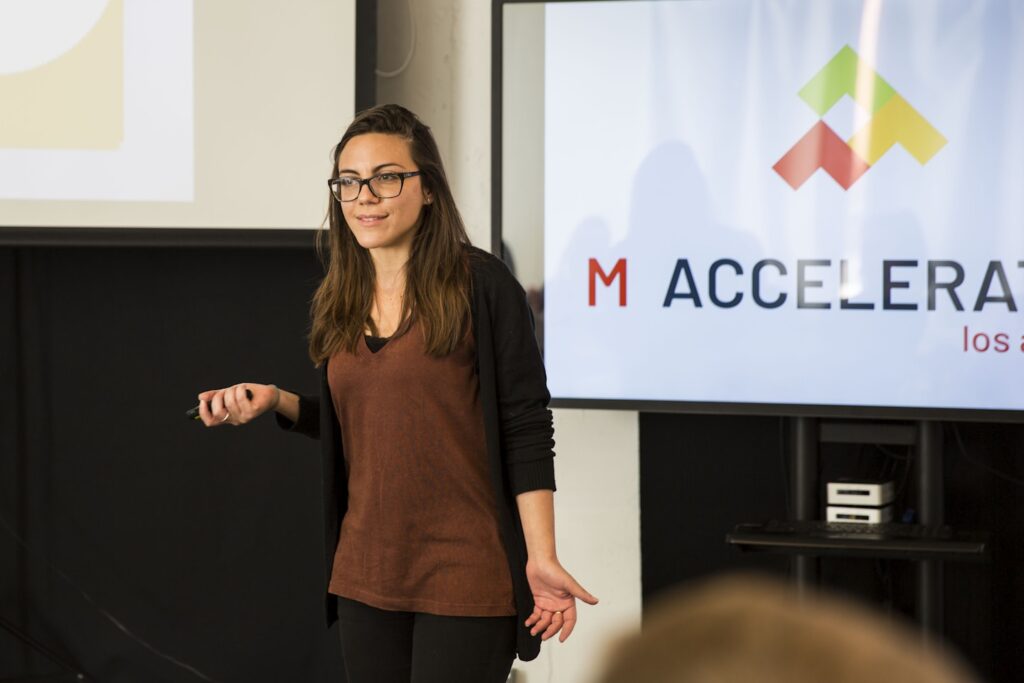 a woman standing in front of a projection screen