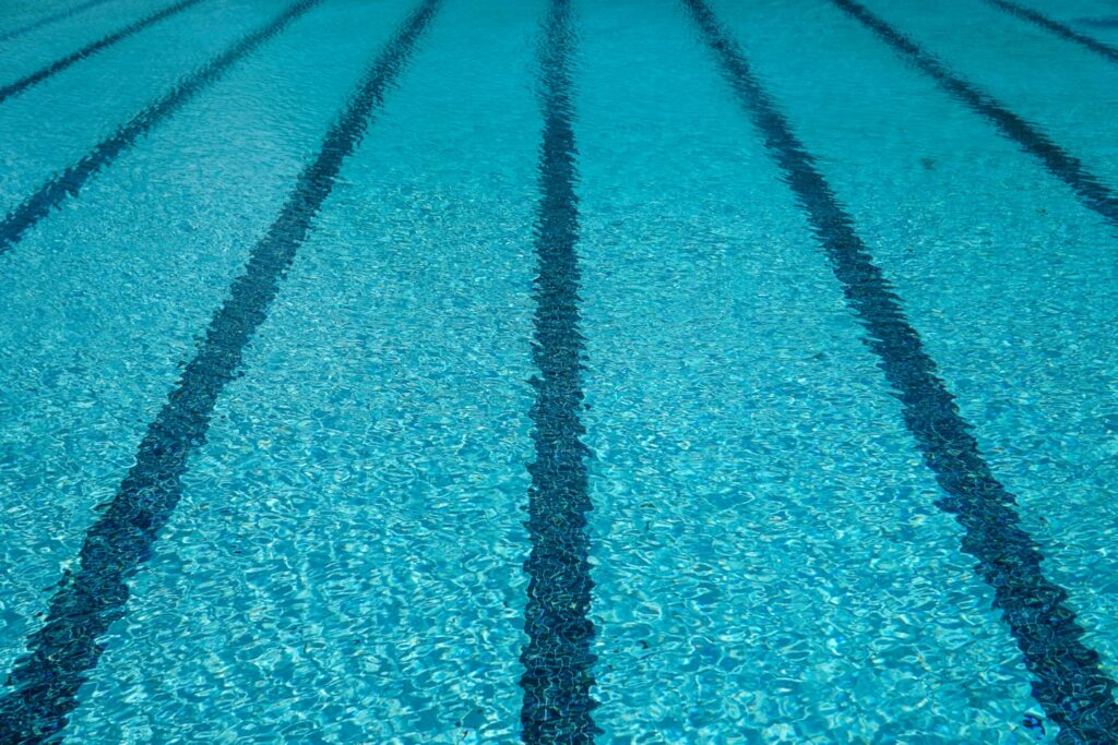 Striped lines beneath clear cold blue swimming pool water during the summer ready for a swim